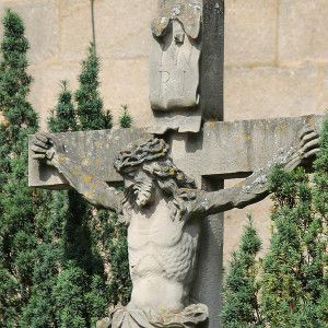 Kreuz vor begrünter Kirchenmauer;Bild von 445693 auf Pixabay