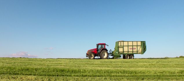 Ein Traktor mit Heuanhänger auf dem Feld