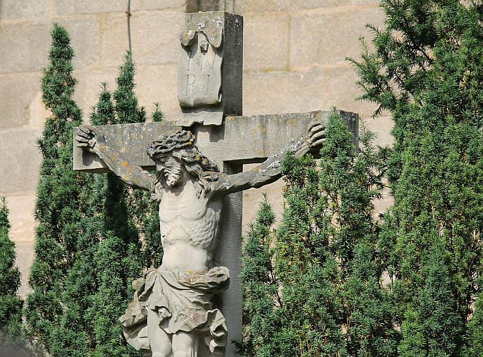 Kreuz vor begrünter Kirchenmauer;Bild von 445693 auf Pixabay