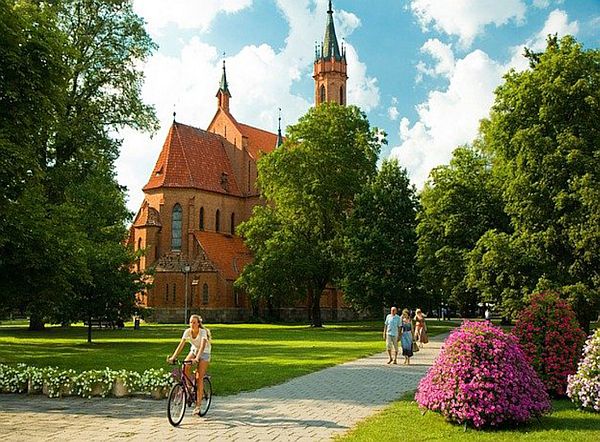 Radfahrerin vor Kirche, Bild von marinabarinova0 auf Pixabay