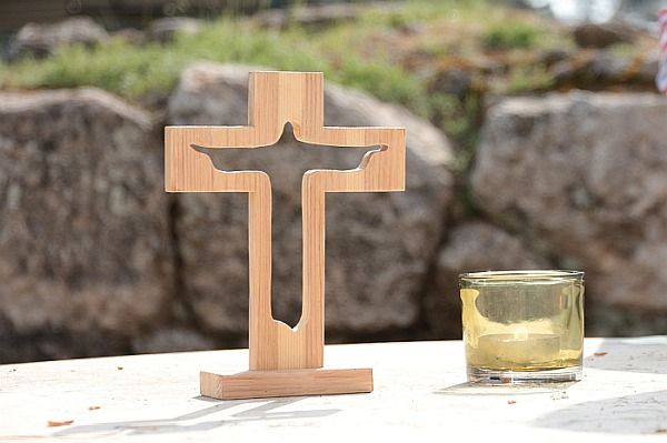 Ein Kreuz und Kerze auf einem Altar im Freien